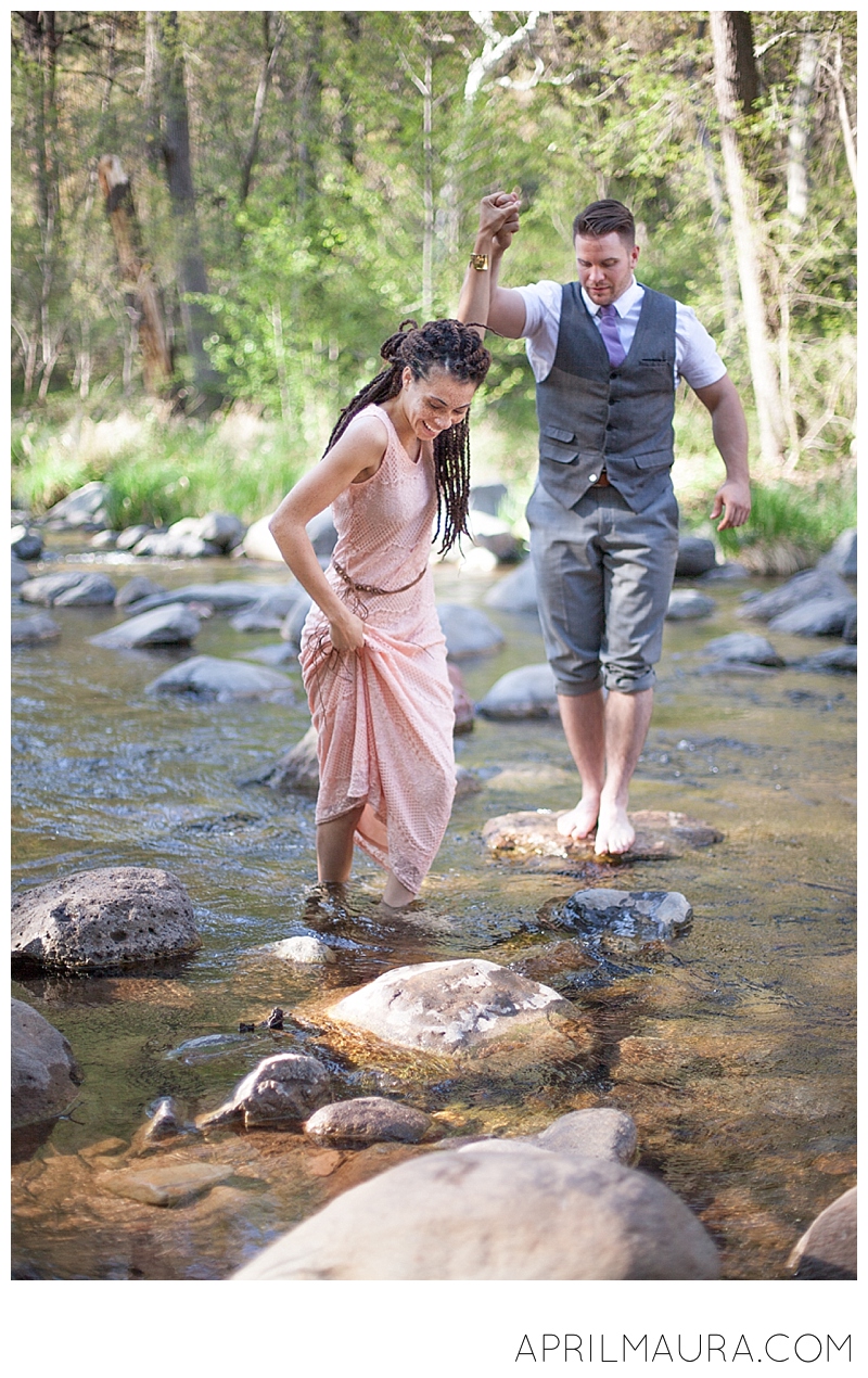 happy engaged couple walking in a creek | sedona engagement photos i-dCfGZ2w.jpg