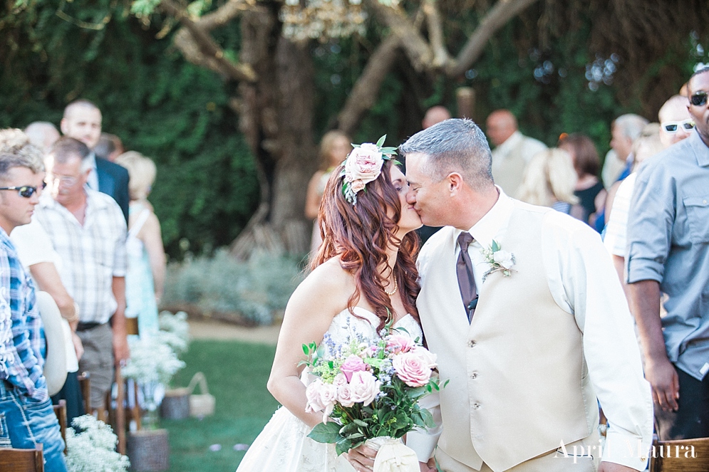 outdoor Arizona wedding space | bride and groom kiss at end of aisle | The_Whispering_Tree_Ranch_Arizona_Wedding_April_Maura_Photography_0024.jpg